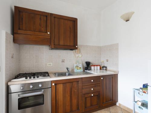 a kitchen with wooden cabinets and a stove top oven at Holiday Home Casa Pina - IMP233 by Interhome in Caramagna Ligure