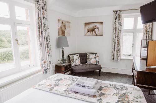 1 dormitorio con cama, silla y escritorio en Leygreen Farmhouse, en Beaulieu