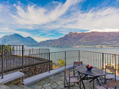 patio ze stołem i krzesłami oraz widokiem na jezioro w obiekcie Apartment Belvedere by Interhome w mieście Bellano