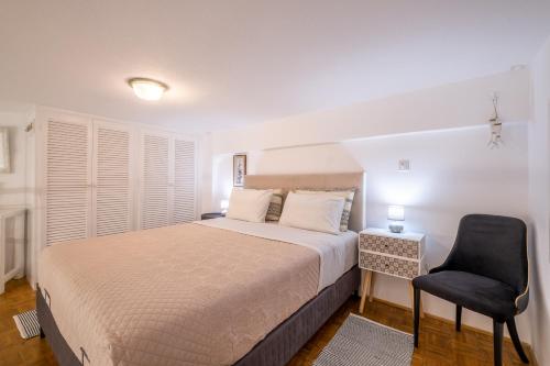 a bedroom with a large bed and a chair at Homebase in Parikia