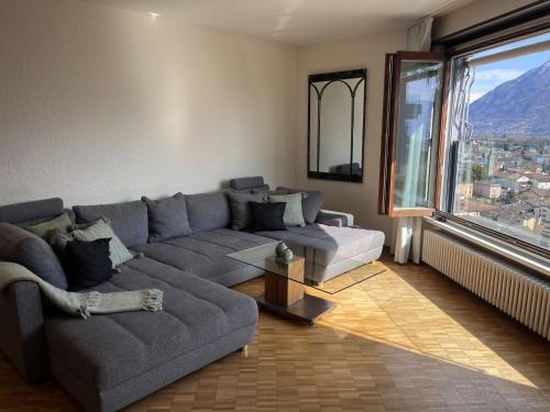 a living room with a couch and a large window at Apartment Suite Classic-16 by Interhome in Ascona