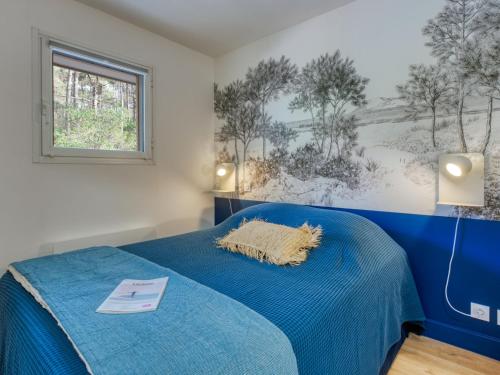 a bedroom with a blue bed and a window at Apartment Village Cheval Spa Résidences-1 by Interhome in Lacanau-Océan