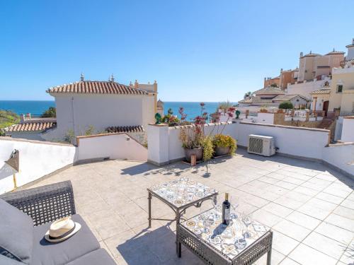 un patio con mesa, sillas y el océano en Holiday Home Villa Tamango Hill by Interhome, en Nerja