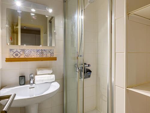 une salle de bain blanche avec un lavabo et une douche dans l'établissement Studio Le Béniguet by Interhome, à Légenès
