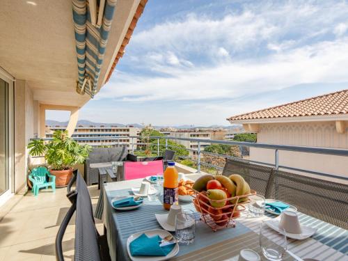 a table with a bowl of fruit on a balcony at Apartment Royal Marine-2 by Interhome in Fréjus