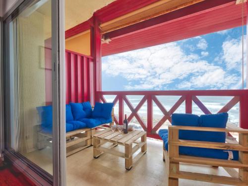 a balcony with blue chairs and a view of the ocean at Apartment Primavéra-7 by Interhome in Lacanau-Océan