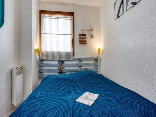 Cette chambre comprend un lit bleu et une fenêtre. dans l'établissement Apartment Primavéra-7 by Interhome, à Lacanau-Océan
