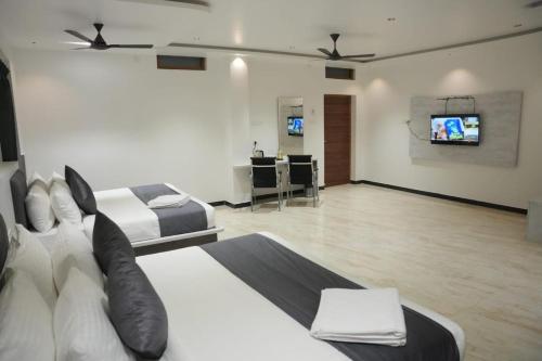 a bedroom with two beds and a flat screen tv at Goldeye's Inn in Erode