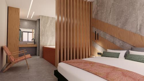 a bedroom with a bed and a chair in it at Elite luxury suites Bali Rethymno in Bali