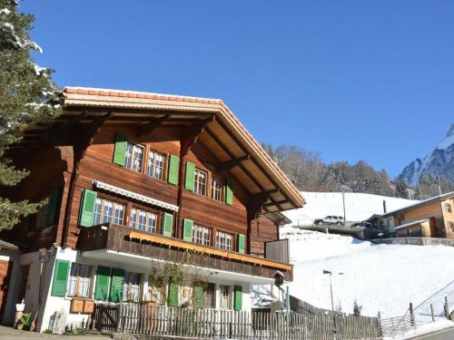 un gran edificio de madera con ventanas con contraventanas verdes en Apartment Chalet Zimmermann by Interhome, en Kiental