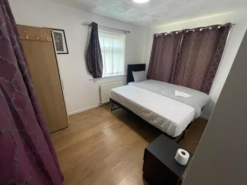 a small bedroom with a bed and a window at Crompton Haven, Liverpool Accessible Home in Liverpool