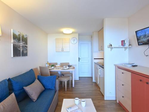 un salon avec un canapé bleu et une cuisine dans l'établissement Apartment L'Esquinade - P5 317 by Interhome, à Agay