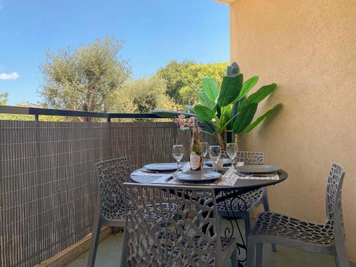 une table avec des verres et des fleurs sur un balcon dans l'établissement Apartment Cimiez Les Pins by Interhome, à Nice