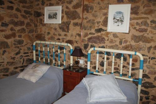 1 dormitorio con 2 camas y mesa con lámpara en El Urogallo de Rucayo en Boñar