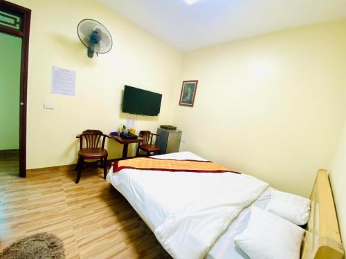 una camera con letto e scrivania con TV di HOTEL HOÀNG LONG a Dien Bien Phu