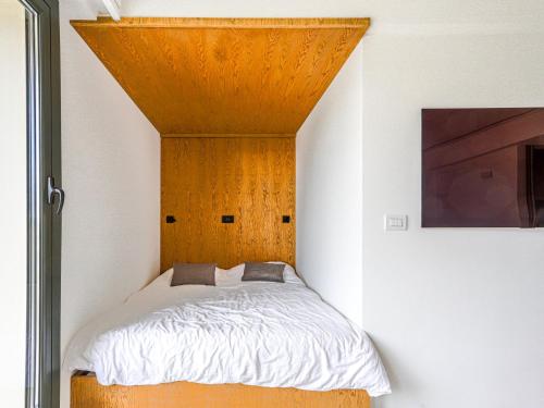 une petite chambre avec un lit et une tête de lit en bois dans l'établissement Apartment Le Copacabana by Interhome, à Nice