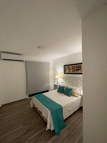 1 dormitorio con 1 cama grande con almohadas verdes en Hermoso departamento funcional Torre Pacha en Santiago del Estero
