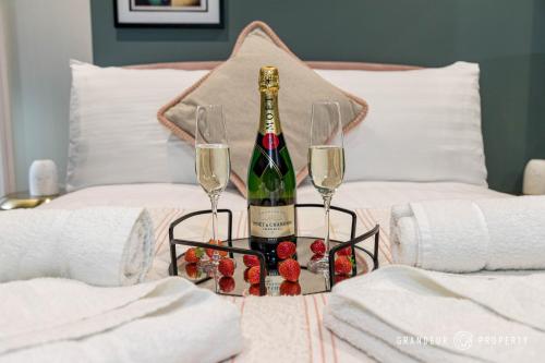 una bottiglia di champagne e due bicchieri su un letto di BRAND NEW light & airy 1 bed, Bmth centre, beaches - Hip Nautic a Bournemouth