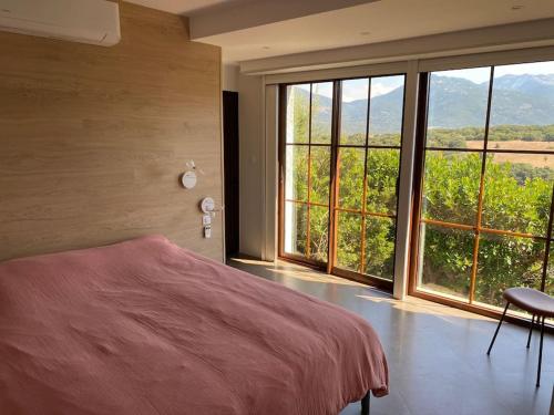 a bedroom with a bed and a large window at Maison Conviviale, Vue Mer in Propriano