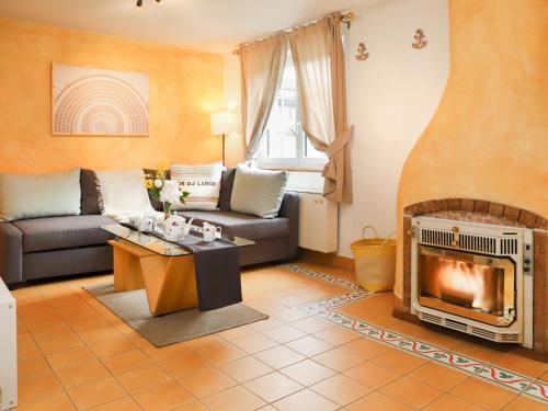 ein Wohnzimmer mit einem Sofa und einem Kamin in der Unterkunft Holiday Home Le Mas Saphir by Interhome in Bouveret