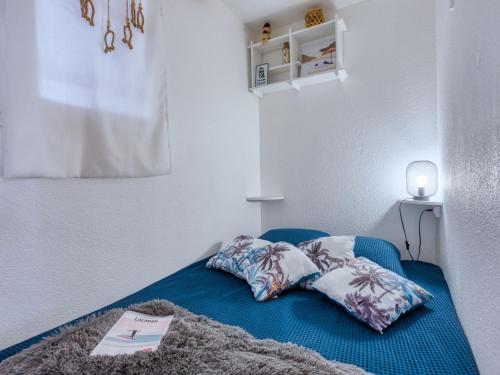 a blue bed with two pillows on top of it at Apartment Primavéra-12 by Interhome in Lacanau-Océan