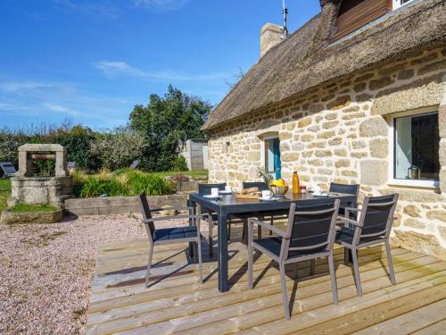 a table and chairs on a wooden deck in front of a building at Holiday Home la chaumière de Quélarn by Interhome in Plobannalec-Lesconil