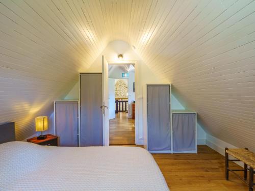 a bedroom with a white bed and a hallway at Holiday Home la chaumière de Quélarn by Interhome in Plobannalec-Lesconil