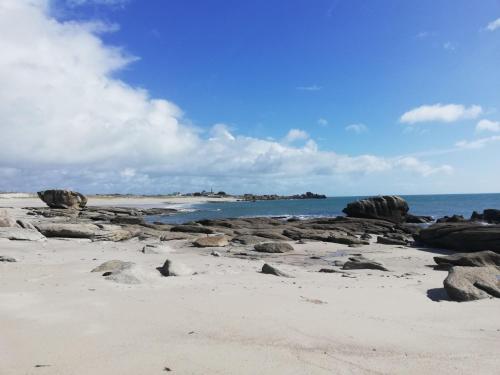 a beach with rocks and the ocean in the background at Holiday Home la chaumière de Quélarn by Interhome in Plobannalec-Lesconil