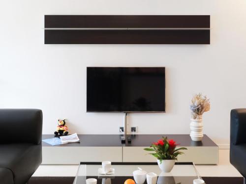 a living room with a tv on the wall at Apartment Les Terrasses C1-7 by Interhome in Montreux
