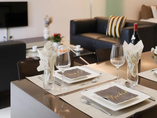 a table with glasses and plates and a bottle of wine at Apartment Les Terrasses C1-7 by Interhome in Montreux