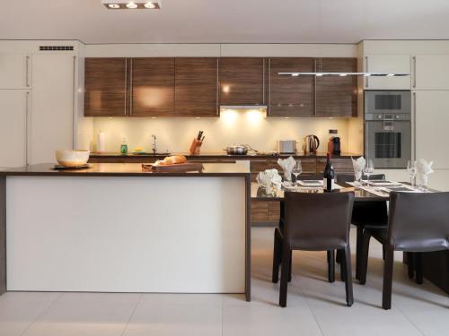 a kitchen with a table and some chairs in it at Apartment Les Terrasses C1-7 by Interhome in Montreux