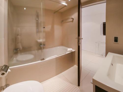 a bathroom with a tub and a toilet and a sink at Apartment Les Terrasses C1-7 by Interhome in Montreux