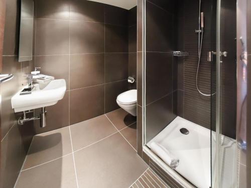 a bathroom with a toilet and a sink and a shower at Apartment Les Terrasses C1-7 by Interhome in Montreux