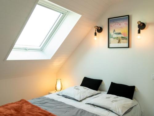 a attic bedroom with a bed and a window at Apartment Les Oyats by Interhome in Clohars-Carnoët