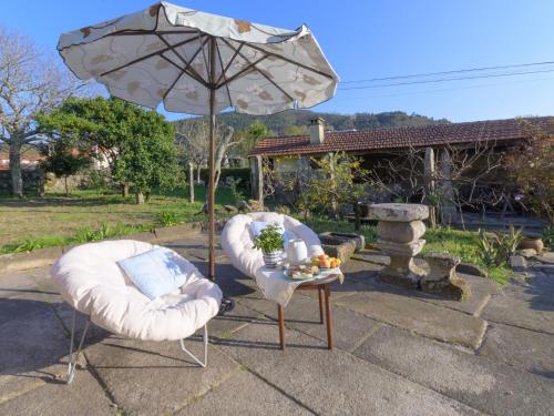 two chairs and a table with an umbrella at Holiday Home Pedra by Interhome in Caminha
