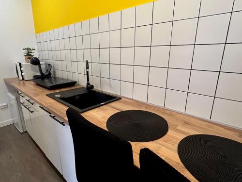 uma cozinha com um lavatório e uma mesa com cadeiras em ALTiDude em Cluj-Napoca
