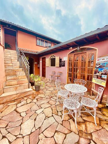 a patio with a table and chairs and a building at Hospedaria Vila Rica - 1 km do centro histórico in Ouro Preto