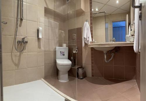 a bathroom with a toilet and a sink and a shower at Hotel Cosmos in Ruse