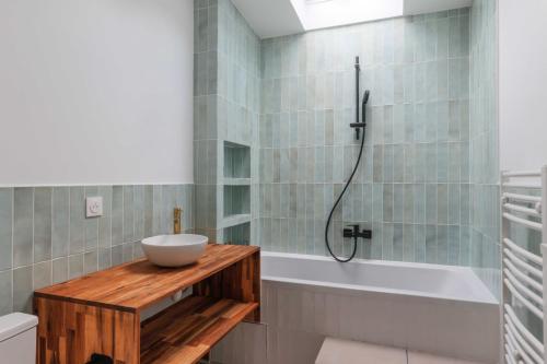 La salle de bains est pourvue d'un lavabo et d'une baignoire. dans l'établissement Bright two storey house - Quais de la Seine, à Asnières-sur-Seine
