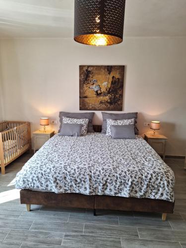 a bedroom with a bed and two lamps and a painting at Melody Huis in Poroszló