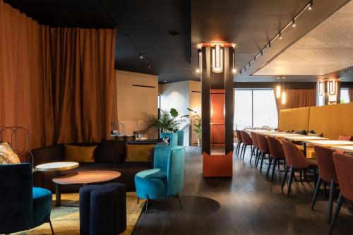 a restaurant with a couch and tables and chairs at Oceania Le Conti in Brest