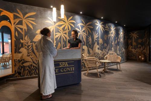 a woman standing next to a man in a spa treatment room at Hôtel & Spa Oceania Le Conti in Brest
