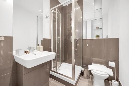 uma casa de banho com um WC, um lavatório e um chuveiro em Loft-style 3 bed apartment in Hoxton London! em Londres