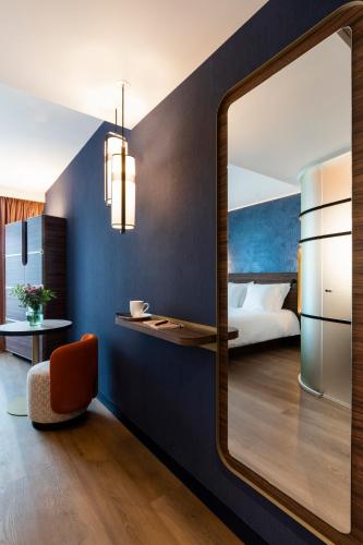 a room with a mirror and a bed and a bedroom at Hôtel & Spa Oceania Le Conti in Brest