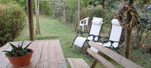 eine Terrasse mit 2 Stühlen und einem Holztisch in der Unterkunft Affittacamere la Casella Monteriggioni in Monteriggioni
