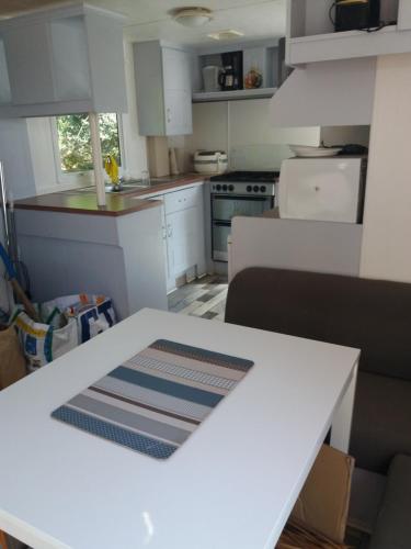 une cuisine avec des armoires blanches et une table blanche dans l'établissement SAS CAMPING PARC MONTANA, à Gassin