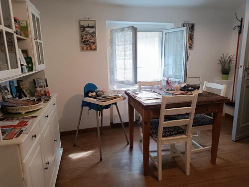 eine Küche mit einem Holztisch und Stühlen sowie einem Fenster in der Unterkunft Trentapassidairolli in Genua