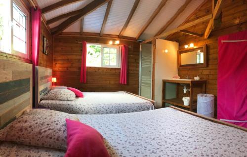 a bedroom with two beds in a wooden cabin at Maison coloniale 12/16 pers. in Pointe-Noire