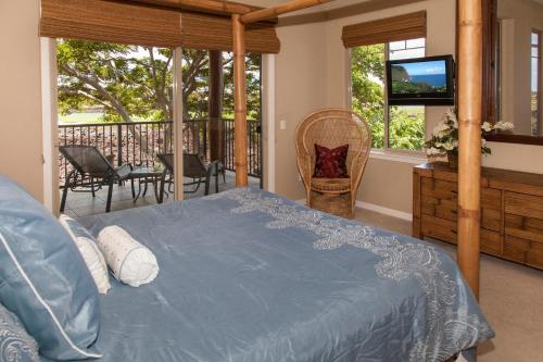 um quarto com uma cama, uma televisão e uma varanda em Mauna Lani Golf Villas K5 em Waikoloa