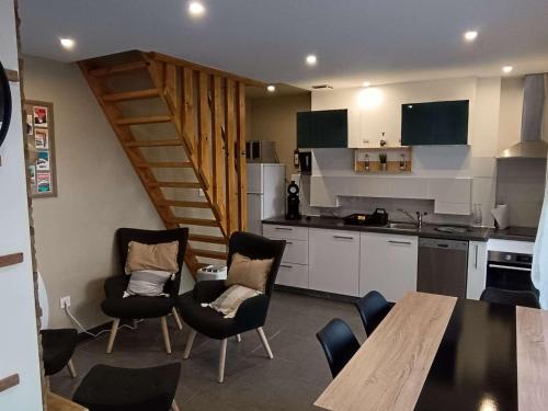 une cuisine avec une table et des chaises ainsi qu'un escalier dans l'établissement Charmant duplex T3 pour 4 personnes, terrasse privative, à proximité des thermes de Luz-Saint-Sauveur - FR-1-402-130, à Luz-Saint-Sauveur